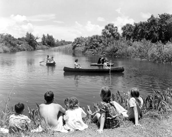 Children watch people canoeing at Hugh Taylor Birch State Park - Fort Lauderdale, Florida.