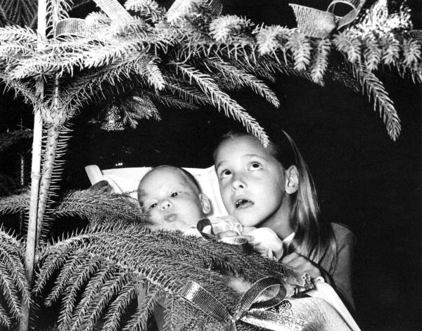 Adriana Dolabella and younger sister Claudia Kirk looking at christmas tree.