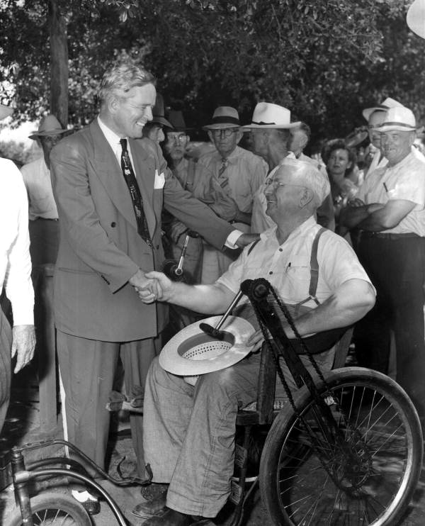 Fuller Warren greeting man in a wheelchair during gubernatorial campaign
