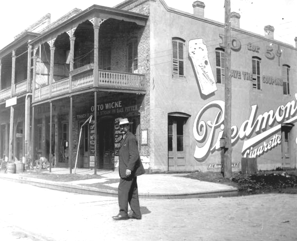Man walking in the street in front of building - Pensacola, Florida.