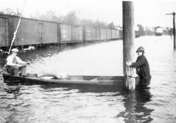 People in boat at flooded railroad yard - Chattahoochee, Florida.