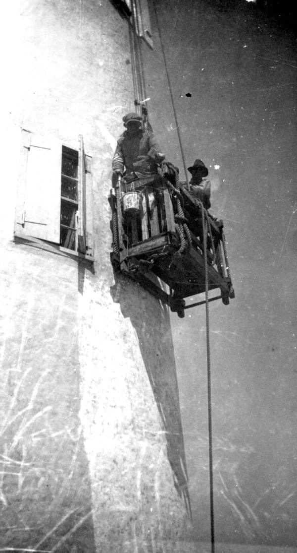Workers painting the lighthouse from a scaffold - Pensacola, Florida.