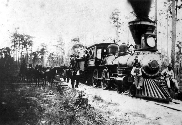 Railroad employees gathered on steam locomotive