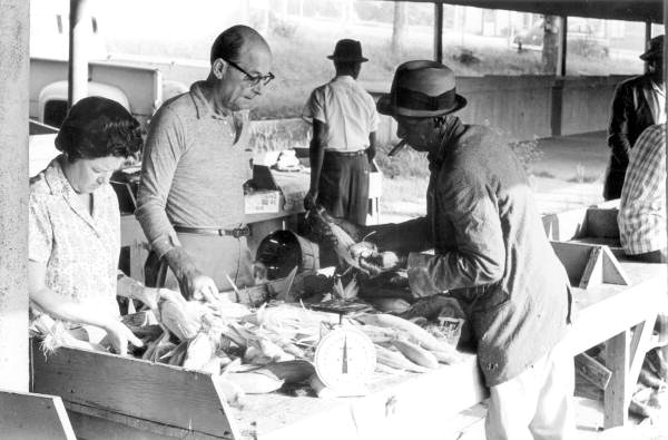 People purchasing corn at the curb market - Tallahassee, Florida.
