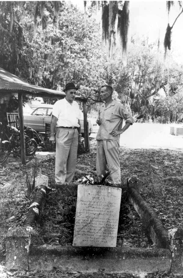 Two men standing before the grave of Arabella "Polly" Taylor - Enterprise, Florida