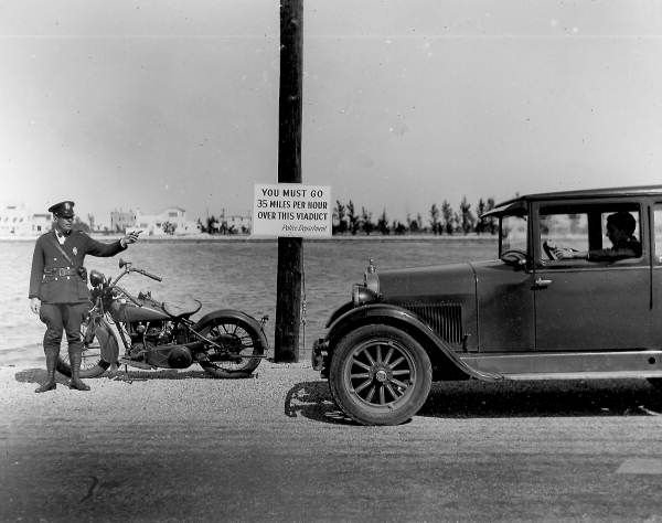 Motorcycle cop directing traffic on county causeway - Miami Beach, Florida.