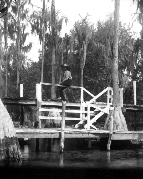 A man sitting on dock at Santa Fe Lake - Melrose, Florida