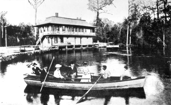 People in rowboat by railroad depot at Silver Springs