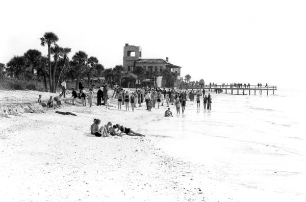 People on the beach adjacent to a hotel - Venice, Florida.