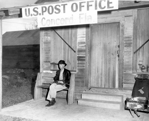 James Benjamin Walsh sitting on bench outside post office building - Concord, Florida