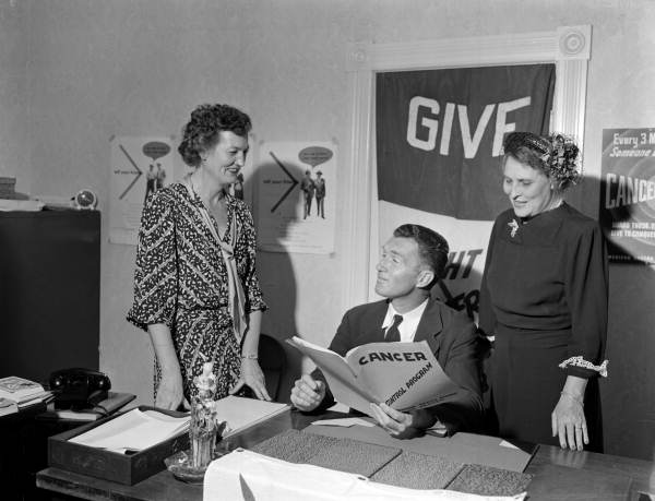 Campaign chairman Joe Walsh from the Duval County Chapter of the American Cancer Society looking at book with unidentified women - Jacksonville, Florida
