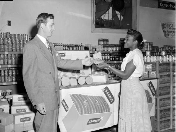 Mr. Higgins handing Armour brand hot dogs to an unidentified woman - Jacksonville, Florida.