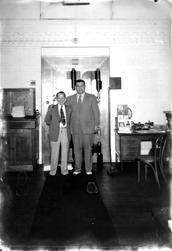 Unidentified men stand in front of a safe