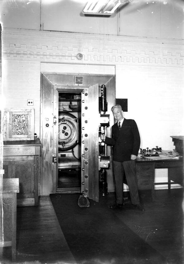 Unidentified man stands in front of a safe