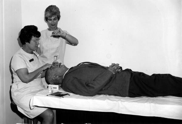 Mrs. Gladys Williams and an unidentified nurses administer a medical test