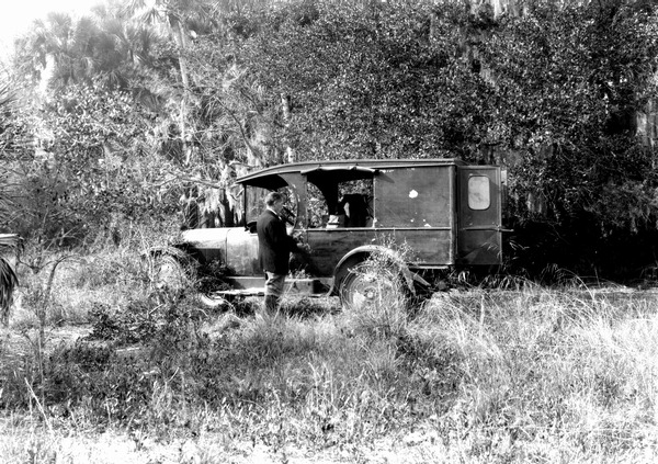 Man standing beside collecting truck