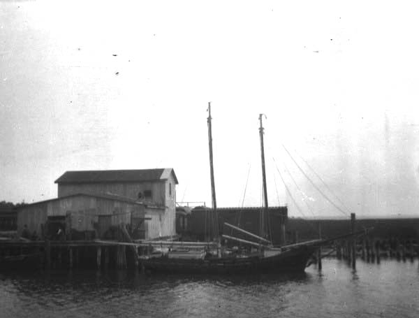 Large sailing ship at dock in village