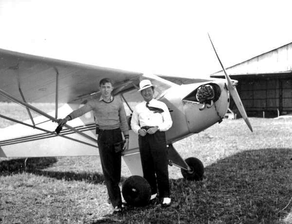 Two men beside an airplane at Penney Farms.