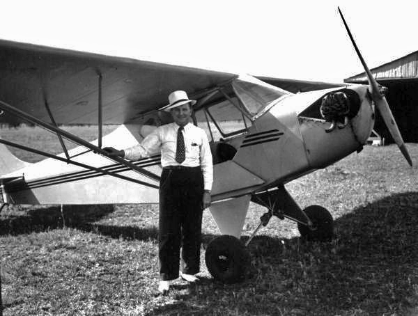 Man standing by an airplane at Penney Farms.