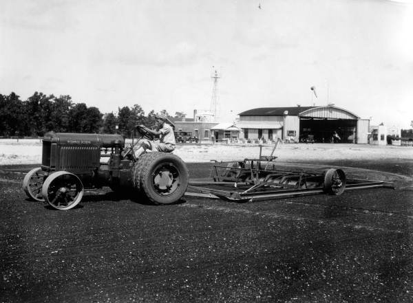 Tractor flattening runway at an airport.