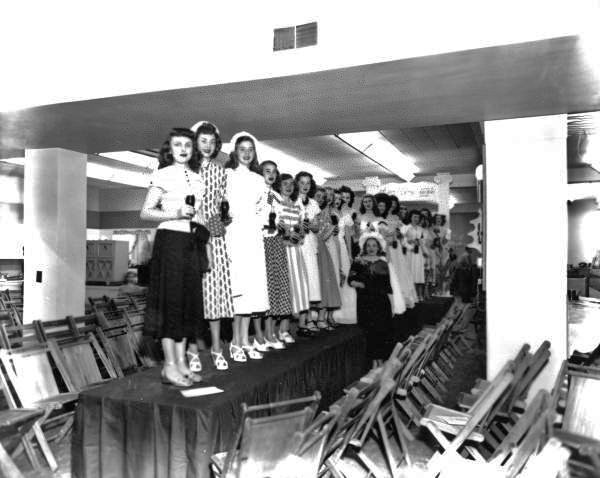 Girls on runway at Furchgott's holding coca cola bottles