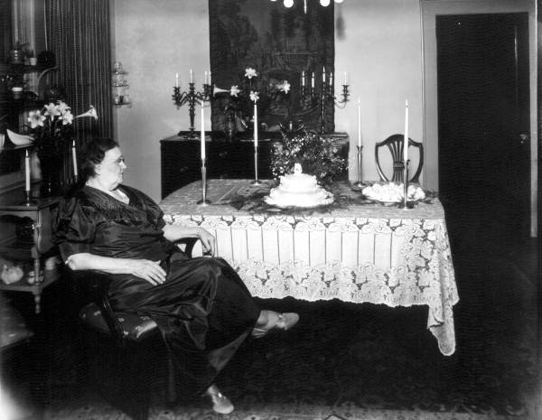 Seated woman sitting beside a tables.