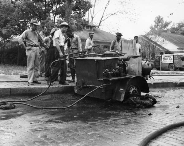 Men viewing damage to tar vat from fire recently extinguished by the Tallahassee Fire Department.
