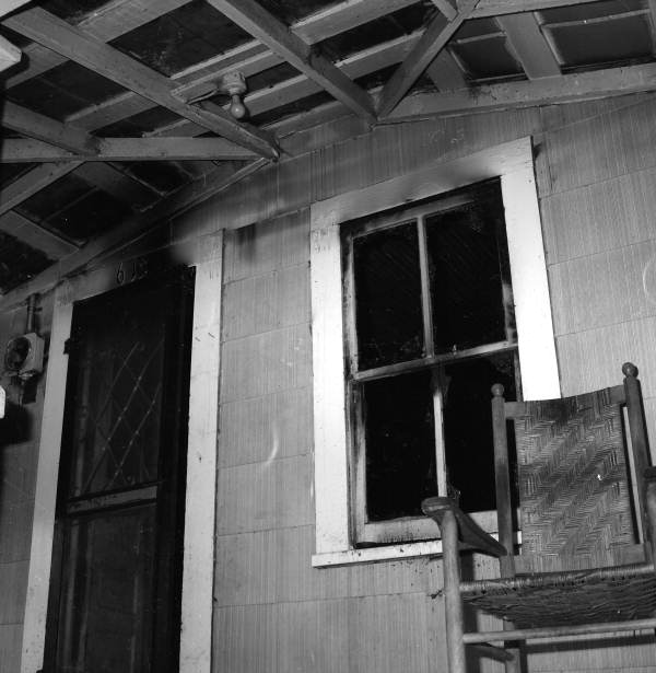 View showing the front door and window of Tom Hadley's house after a fire - Tallahassee, Florida.