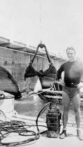 Treasure hunter Art McKee standing next to his diving helmet during project - Moser Channel, Florida