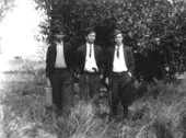 One young man with a suitcase, one with a handgun and one with a shotgun.