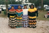 Four Seminole women in traditional clothing at the Brighton Seminole Reservation tribal festival.