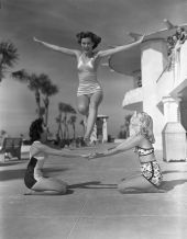 Three young women pose for jumps on the sidewalk at Lido Beach - Sarasota, Florida.