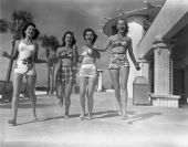 Young women holding hands sauntering in front of a casino - Lido Beach, Florida.