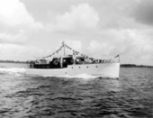 Two elderly men are on a small yacht