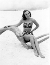 Ann Williamson of Winter Haven, Florida, posing with driftwood on the beach.