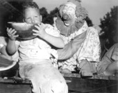 Clown encouraging young boy at the watermelon eating contest in the watermelon festival - Leesburg, Florida