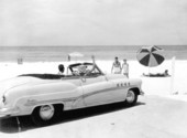 Couple in automobile at Lido Beach waving to friends - Sarasota, Florida.