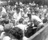 People gathered at tables to get slices of watermelon at the watermelon festival - Leesburg, Florida