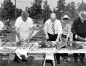 Three men cutting meat and ribs at the Mathews Bridge barbecue - Jacksonville, Florida