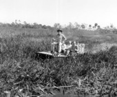 Three delegates from the Inter-American Tourism Conference on an airboat tour
