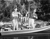 Two fishermen holding a string of fish caught in the Oklawaha River in Ocala National Forest - Welaka, Florida.