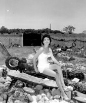 Jackie Sweeting poses on relics displayed outside the McKee's Museum of Sunken Treasure - Plantation Key, Florida