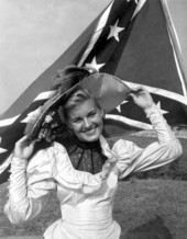 Nancy Beach posing in front of a Confederate flag - Pensacola, Florida.