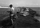View of people fishing from the jetties at St. Andrews State Park - Panama City, Florida.