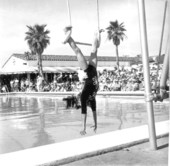 Young girl performing acrobatics at a swimming pool for the Tri-city suncoast festival - Redington Beach, Florida.