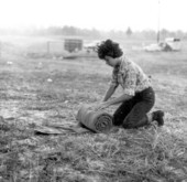 Young woman rolls her sleeping bag after a nights sleep on the Old Spanish Trail