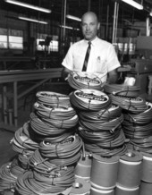 An officer stands behind products in a Mercer Plastics plant - Eustis, Florida.