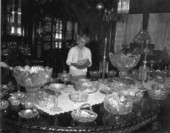 A staff member examining glasses displayed at the Lightner Museum - Saint Augustine, Florida
