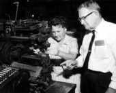 T.T. Wentworth Jr. and a museum staff member stand by a sewing device - Pensacola, Florida.