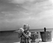 Jamie Prentice, age 6, blowing into a large shell - Key West, Florida